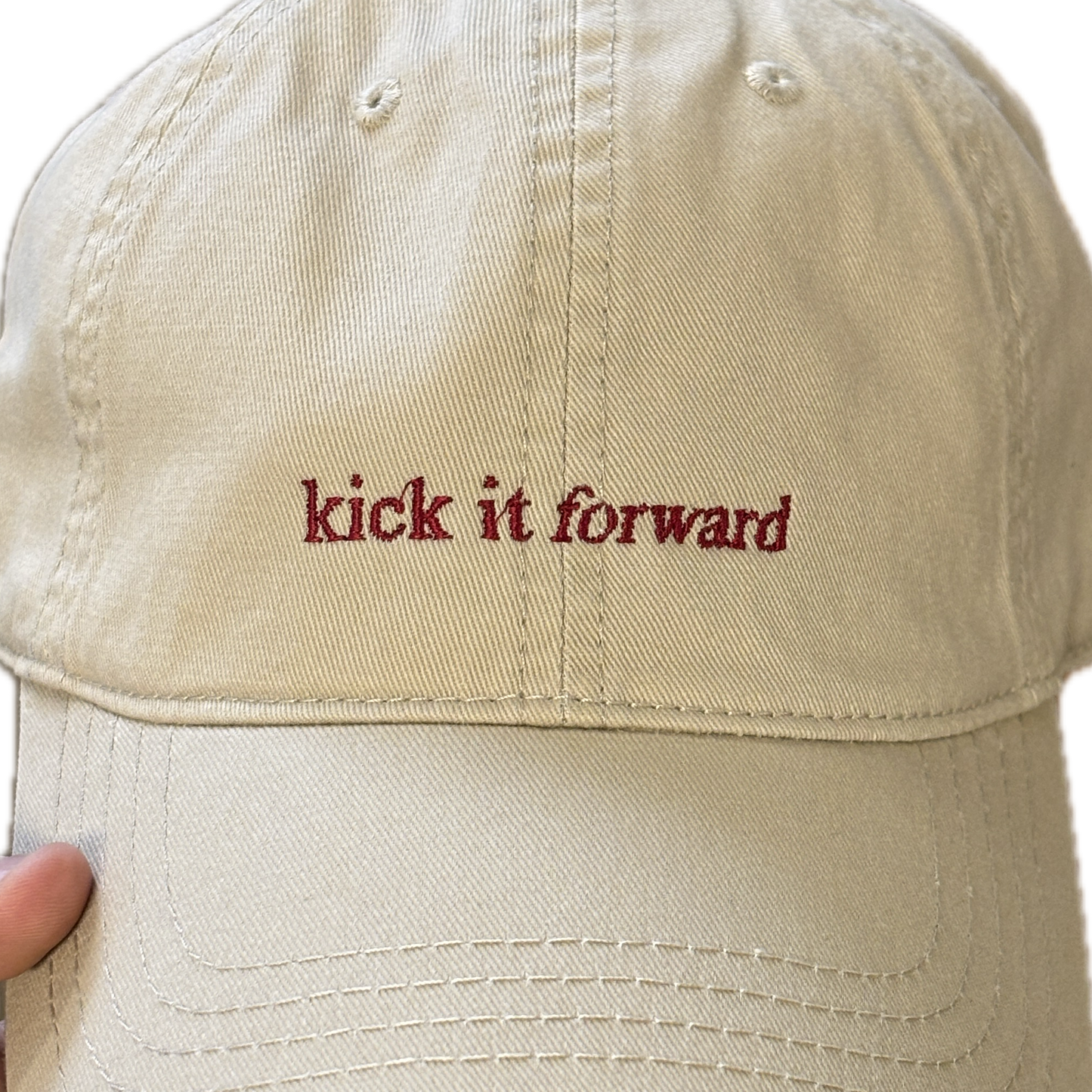 Kick it Forward red text on cream cap